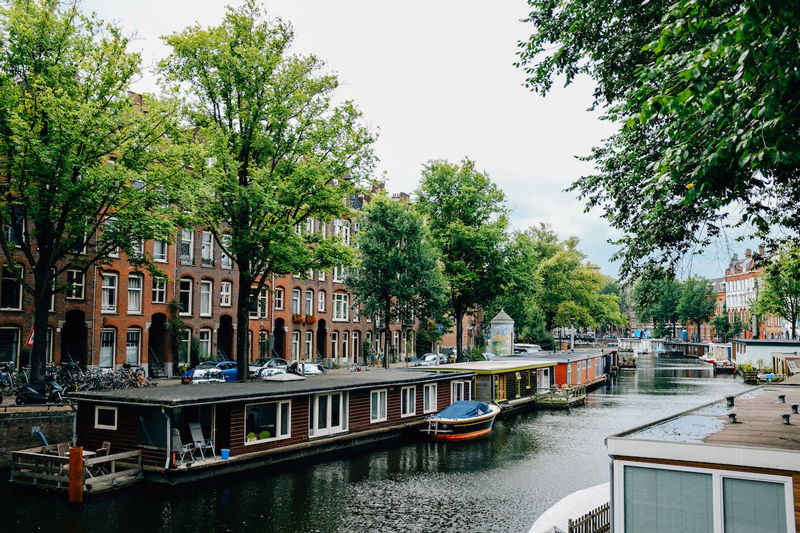 Überall in Amsterdam sieht man Hausboote und treibende Häuser
