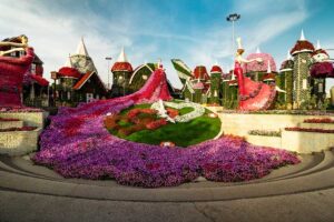 dubai-Gruenes-und-braunes-Haus-umgeben-von-Blumen-unter-blauem-Himmel