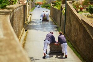 Rodler schieben Holzschlitten bergab in Funchal