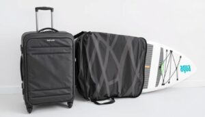 Aqua Marina Fusion SUP Board zusammengerollt neben Reisekoffer für Größenvergleich
