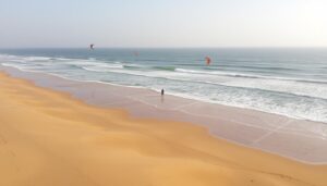 Weitläufiger Strand von Essaouira mit Kitesurfern und Atlantikwellen - Städtereise Essaouira