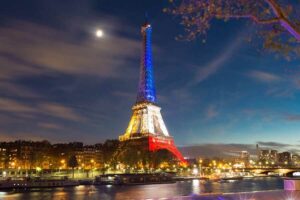 Der Eiffelturm Paris bei Nacht, beleuchtet in den französischen Nationalfarben bei einer besonderen Veranstaltung