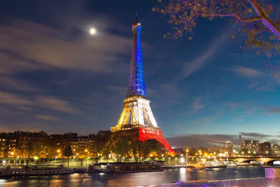 Der Eiffelturm Paris bei Nacht, beleuchtet in den französischen Nationalfarben bei einer besonderen Veranstaltung