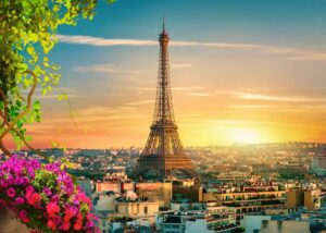 Der Eiffelturm Paris bei Sonnenuntergang, beleuchtet in goldenem Licht mit der Pariser Skyline im Hintergrund