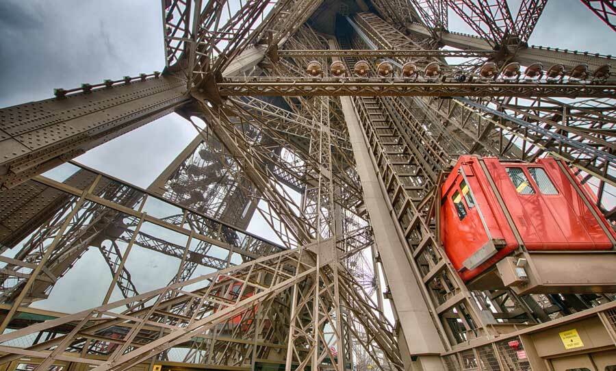 Nahaufnahme der Aufzüge und Treppen des Eiffelturm Paris mit Besuchern