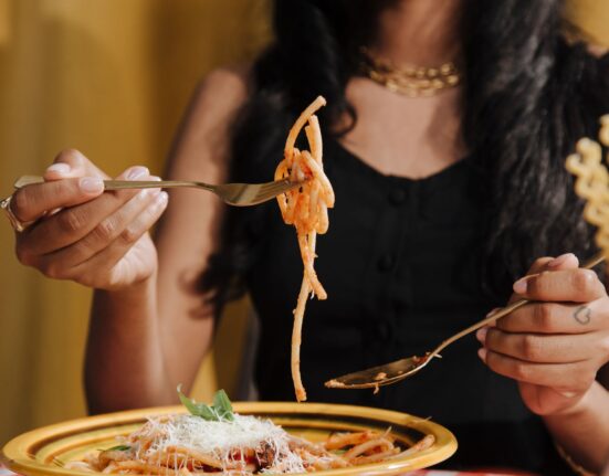 Gedeckter Tisch mit italienischer Pasta, Brot, Käse und Wein