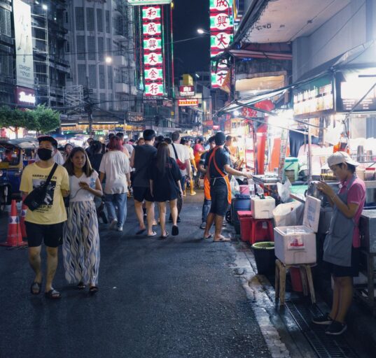 Beleuchtete Streetfood-Stände am Abend in der Yaowarat Road in Bangkoks Chinatown