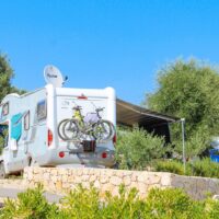 Wohnwagen und Wohnmobile auf einem Campingplatz am Meer im Sommer