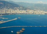 Mittelmeerküste mit Strand, türkisfarbenem Wasser und Bergen im Hintergrund
