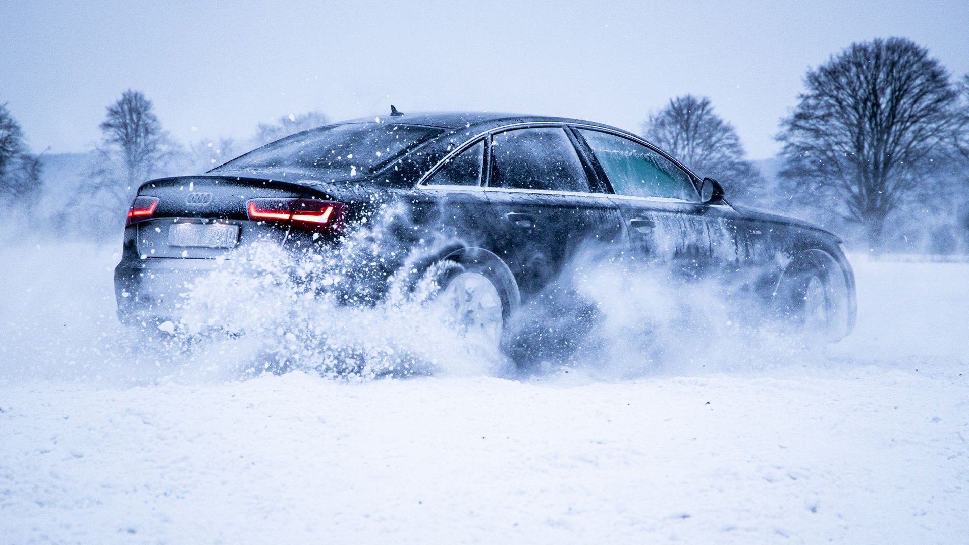 Auto fährt durch aufwirbelnden Schnee