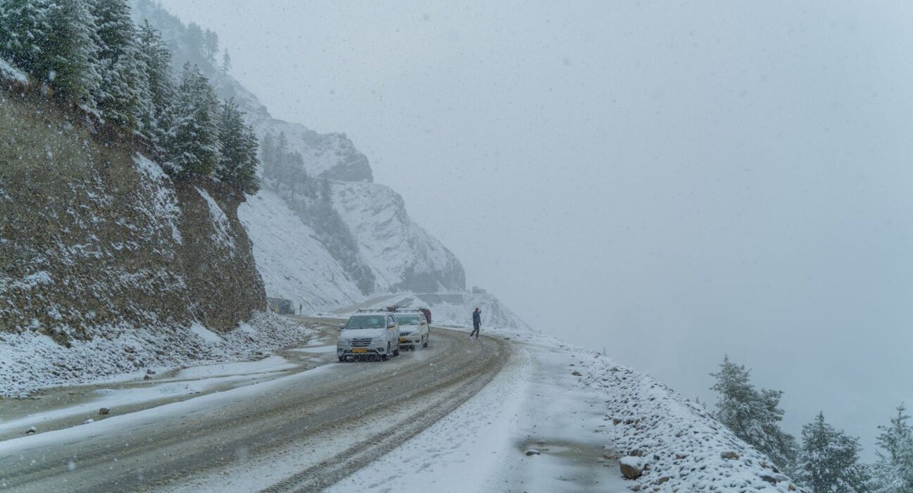 Auto auf einer verschneiten Bergstraße im Winter