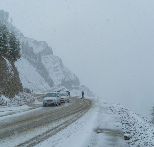 Auto auf einer verschneiten Bergstraße im Winter