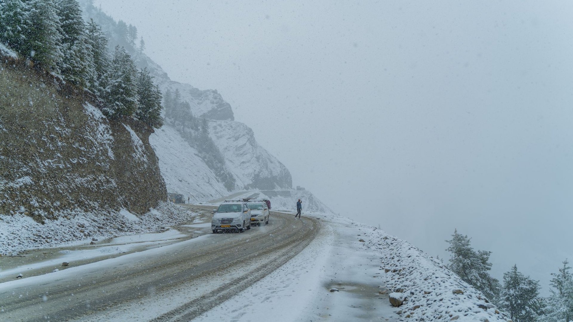 Auto auf einer verschneiten Bergstraße im Winter