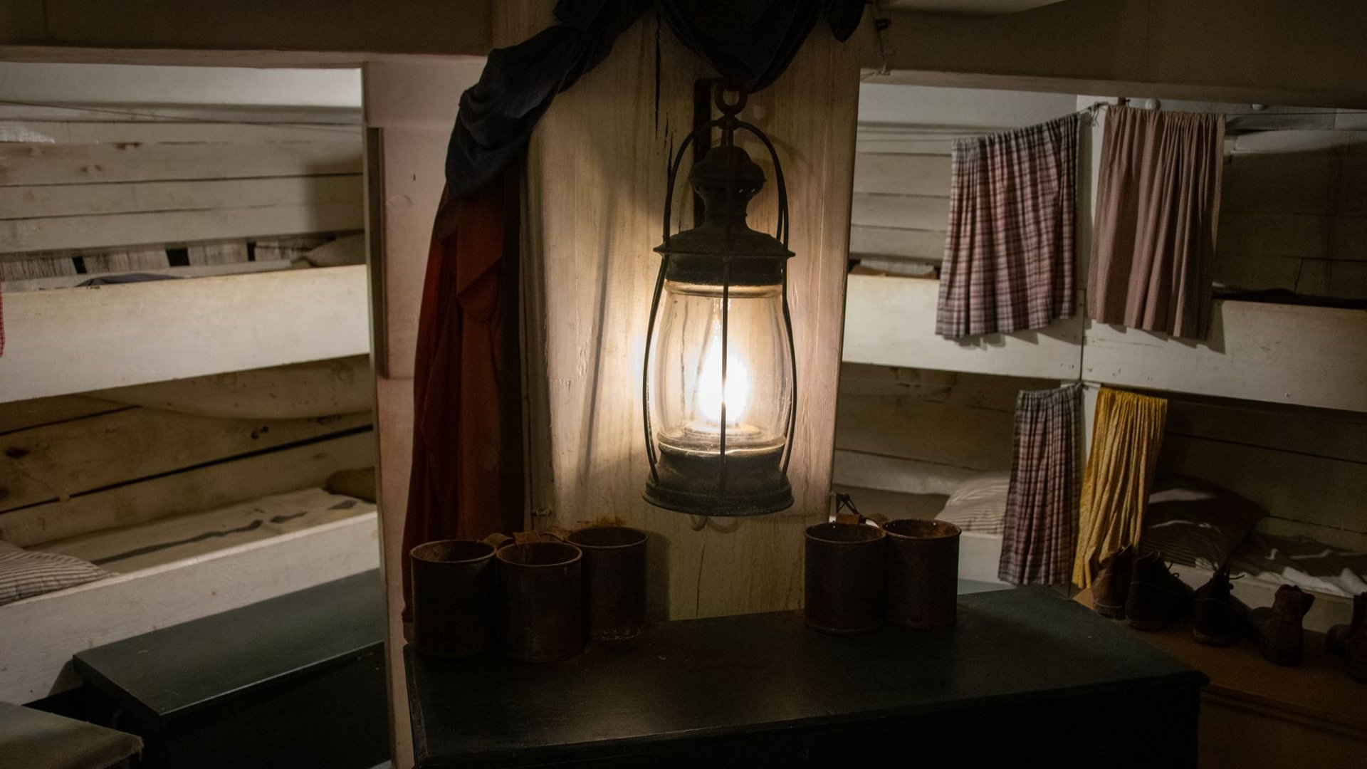Holzbetten und Petroleumlampe in einer einfachen Hütte