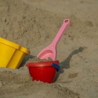 Sandeimer und Schaufeln aus Plastik im Sand