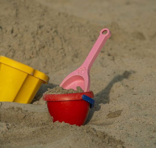 Sandeimer und Schaufeln aus Plastik im Sand