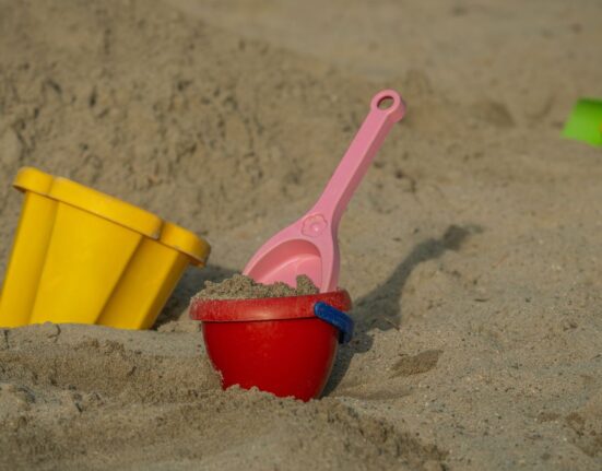 Sandeimer und Schaufeln aus Plastik im Sand