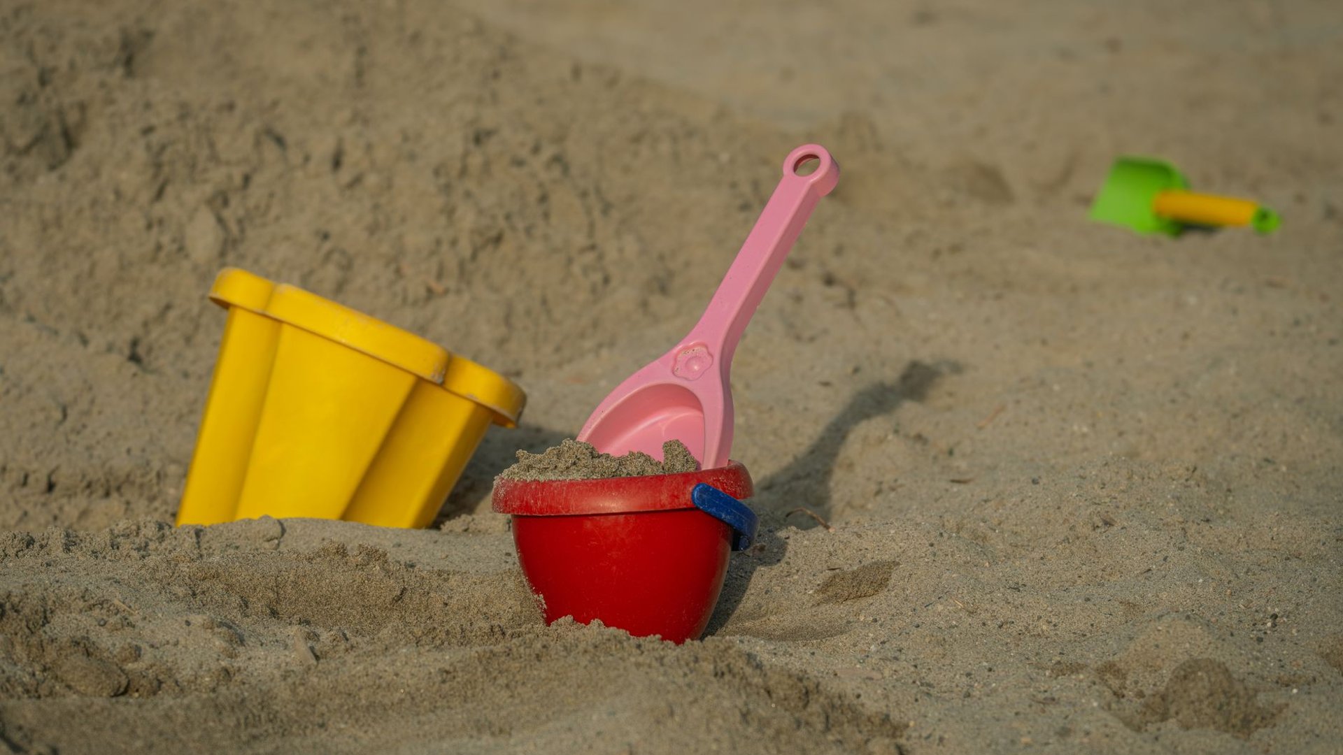 Sandeimer und Schaufeln aus Plastik im Sand